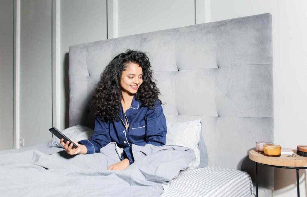 Single Woman in Blue Pajama Sitting on Bed