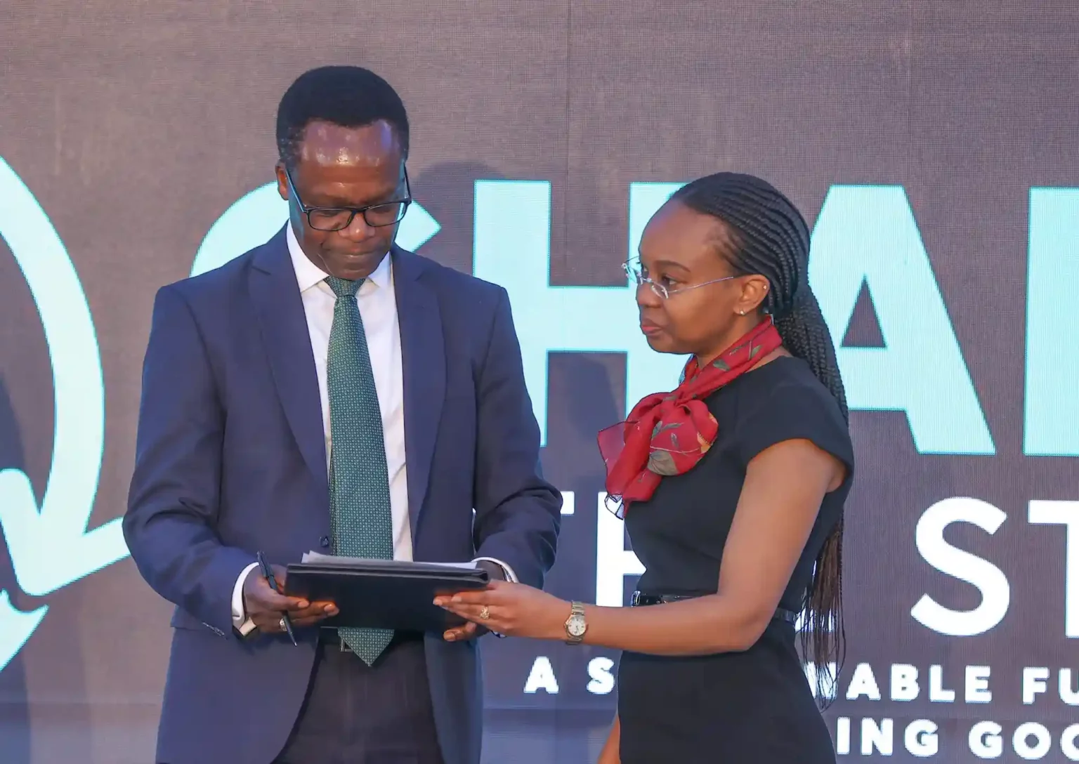 John Gachora, NCBA Group MD signing up to the UN Global Compact during the NCBA sustainability commitments unveil. Looking on is Ms. Judy Njino, Exec. Director- UN Global Compact.