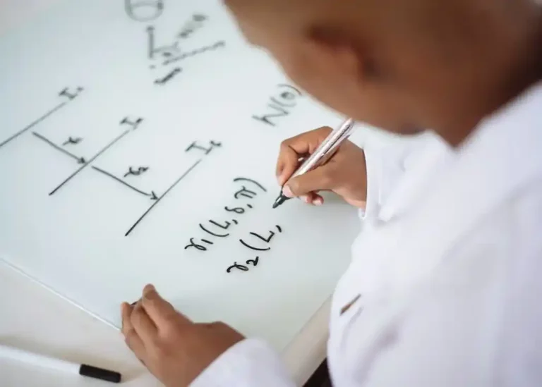 Photo Of Person Deriving Formula On White Board.