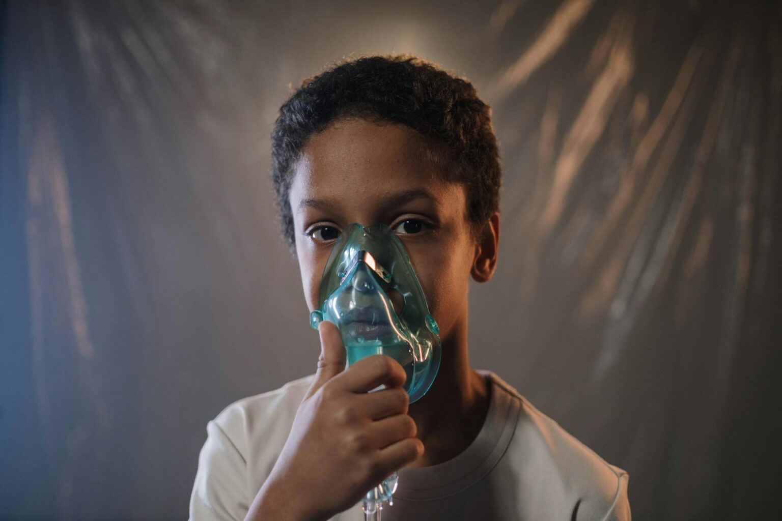 A Boy in White Shirt Holding Green Oxygen Mask. Learn about the causes, symptoms, and treatment options for COPD, and how to reduce your risk.