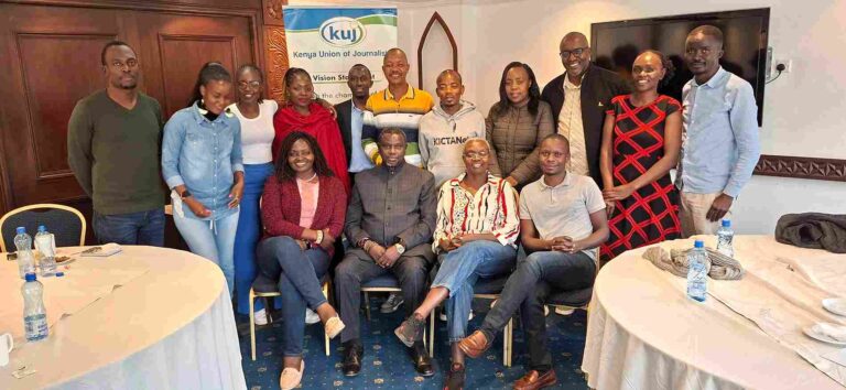 A group of young journalists and facilitators pose together in a well-lit room in Nairobi, smiling after a training session. Behind them is a branded banner for the KUJ–IFJ “Young Journalists and Trade Unions” workshop under the UTU Project 2025, held across two intervals in July.