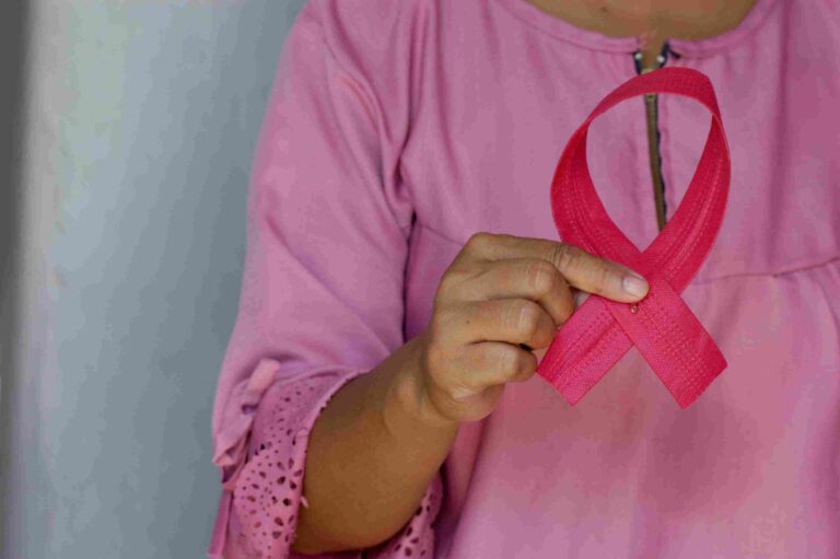 Why Breast Cancer Is Rising Among Younger African Women Woman holding pink ribbon for Breast Cancer Day awareness