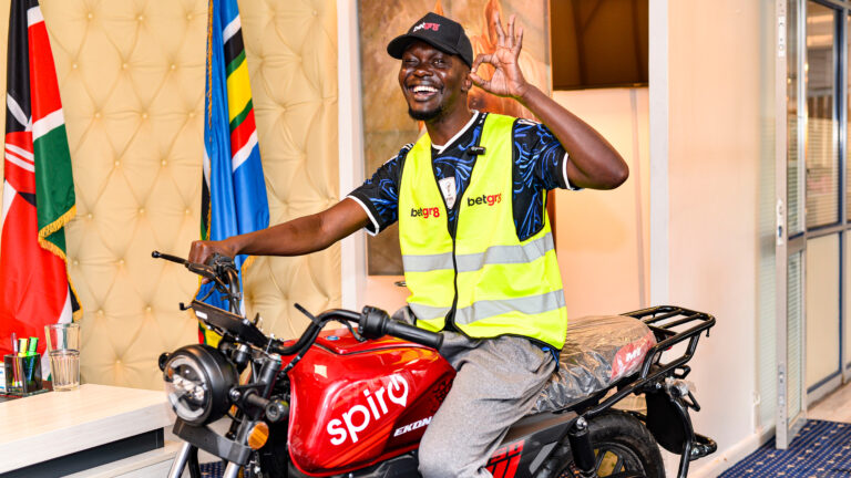 Clinton Odhiambo Odanga holds his Spiro electric bike prize at Uhuru Park after winning the BetGr8 Pepeta Challenge during the World Cup Kick-Off Watch Party in Nairobi.