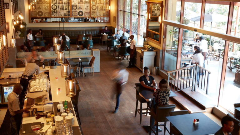 Overhead view of Artcaffé's Westlands, Nairobi restaurant, with staff and diners at the bar, tables and terrace.