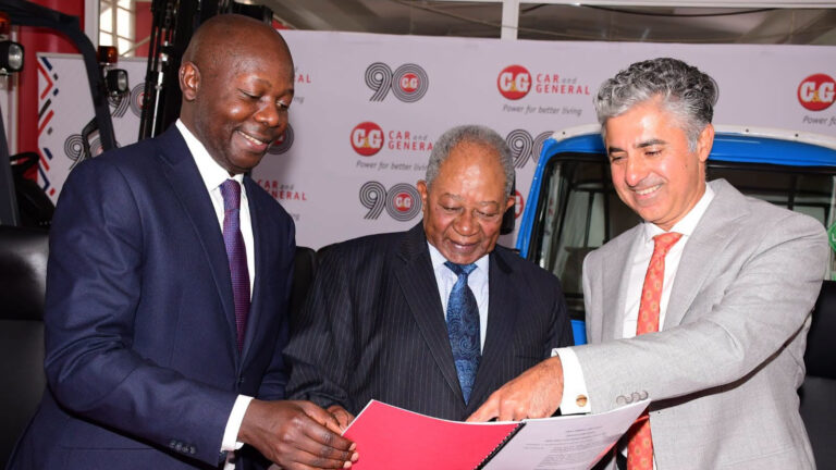 Nicholas Ng'ang'a, Conrad Nyukuri and Vijay Gidoomal review a document at a Car & General event