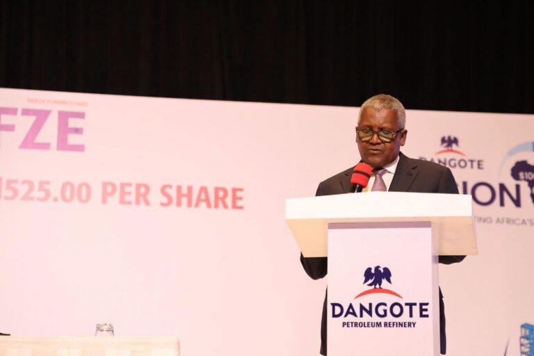 Aliko Dangote speaks at a podium during the signing ceremony for the Dangote Petroleum Refinery IPO, with a screen behind him showing the offer price of 525 naira per share.