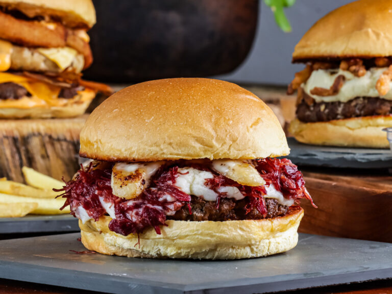 A close up of gourmet burgers with melted cheese, onion rings and fries, styled for Nairobi Burger Week 2026.