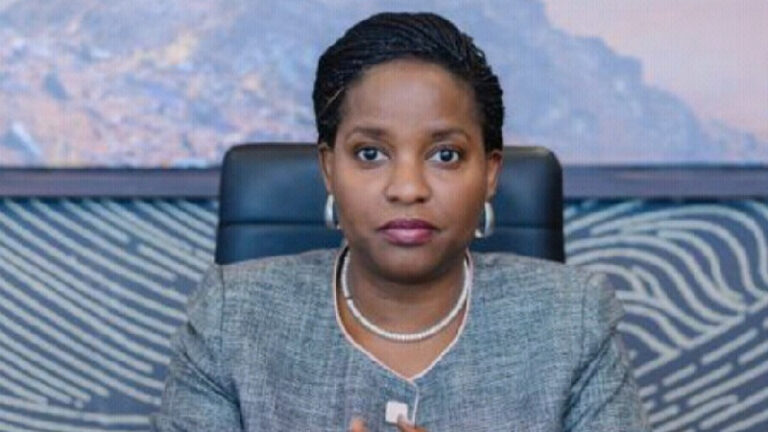 Anne Juuko, Director General of the East African Development Bank, seated at a desk with her hands pressed together.